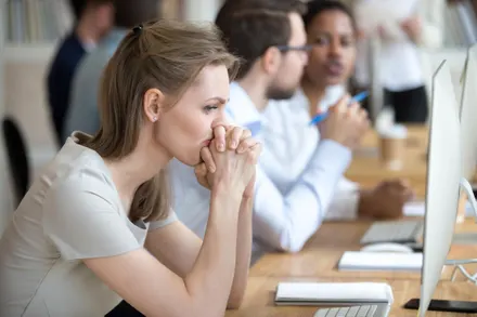 Woman in classroom at computer looking anxious