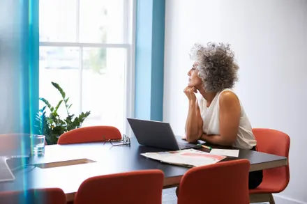 Older woman sitting at table with laptop